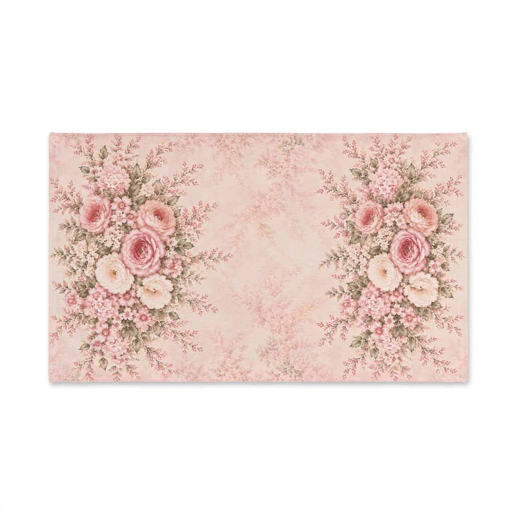 A rectangular decorative hand towel with a vintage floral design in soft pink and cream tones, featuring two large rose bouquets on the left and right sides and a faded damask pattern in the center, shown on a plain white background.